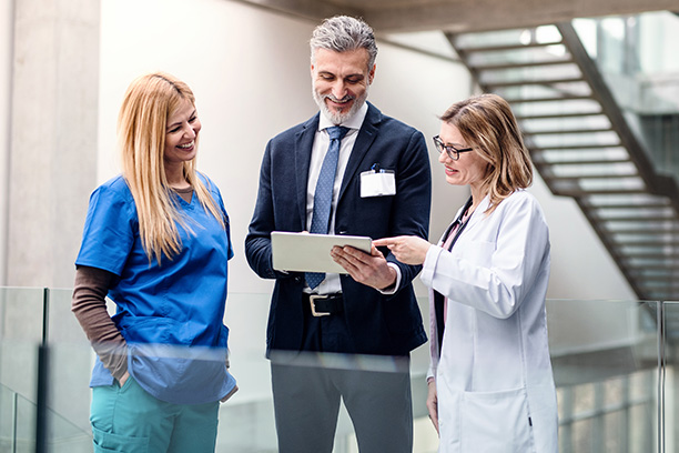 Three medical professionals looking at the Qmap dashboard on a tablet