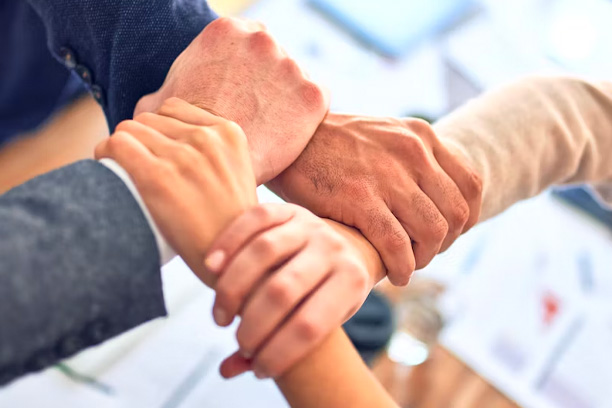 Four people linking arms in a square