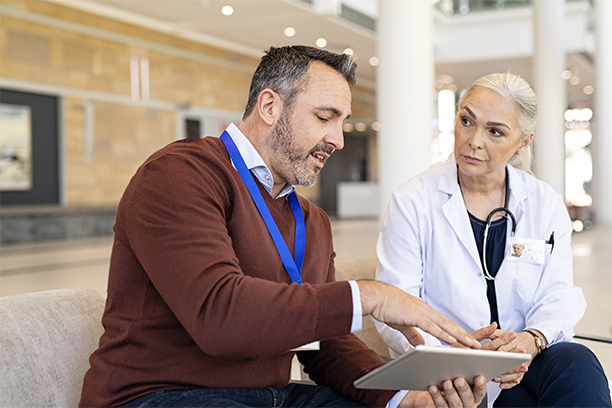 Two medical professionals looking at the Qmap dashboard on a tablet